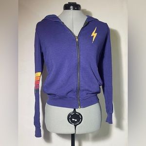 Purple Aviator Nation sweatshirt with a rainbow on the sleeve